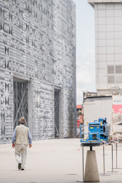 Rinas, Albania - 03 June 2026: View of a man walking past the modern patterned facade of Tirana International Airport.
