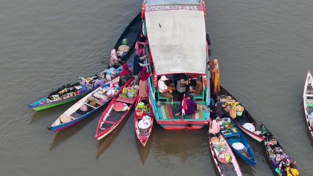 Traders sell fresh produce and interact from their boats at Lok Baintan Floating Market in Borneo