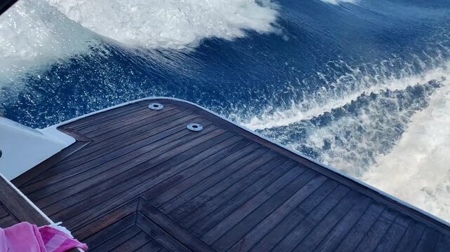 White water foam from speed yacht riding, view on wood stern of luxury boat for sitting and enjoying summer vacation, powerful motorboat riding and splashing water