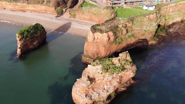 Aerial view of Ladram Bay red sandstone sea stacks and rugged coastline in Devon England.