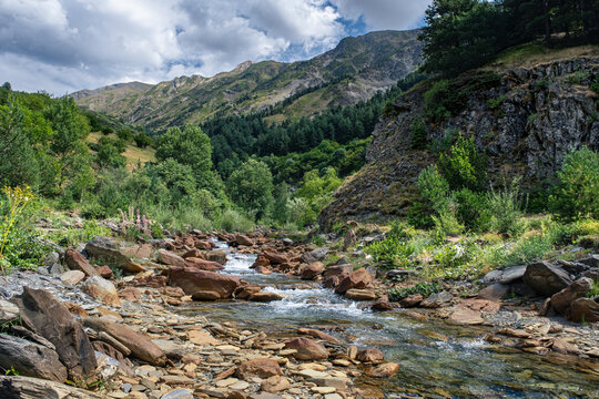 Senderismo por las monta&ntilde;as y valles del Valle de Aran en el Pririneo, caminando junto a un r&iacute;o alpino