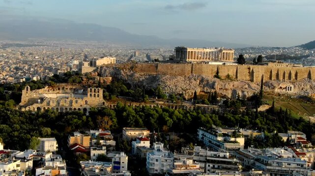 Aerial view of ancient parthenon temple atop acropolis hill in athens greece at sunset.