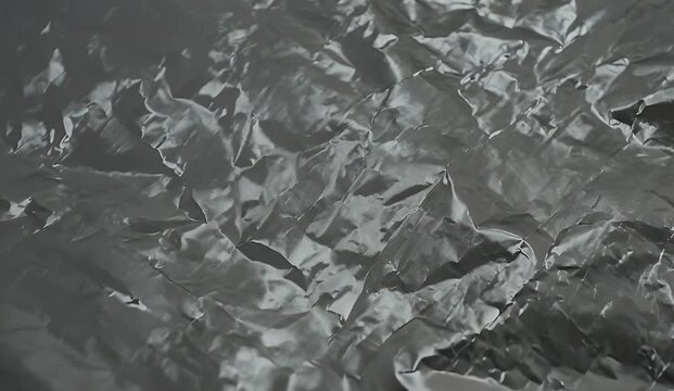 Black crumpled plastic texture with glossy reflections