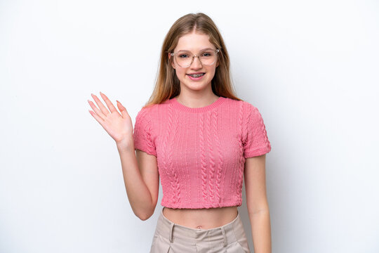 Teenager Russian girl isolated on white background saluting with hand with happy expression