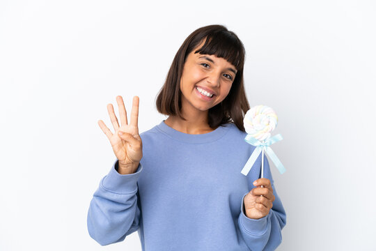 Young mixed race woman holding a lollipop isolated on white background happy and counting four with fingers