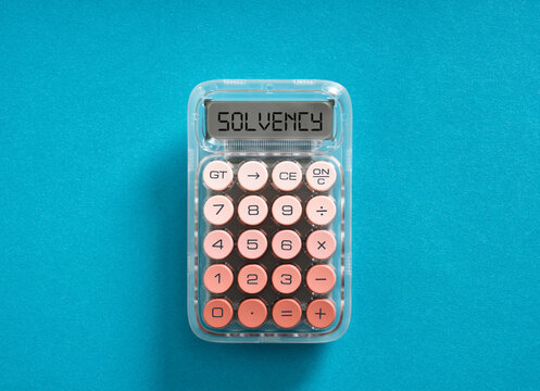 Calculator displaying solvency concept on blue background