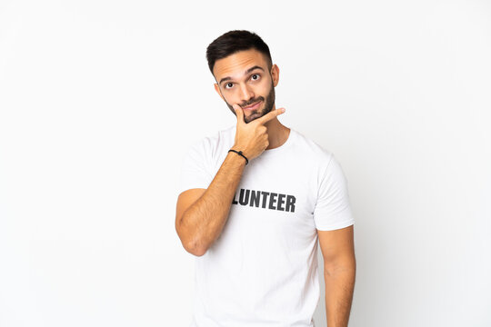 Young caucasian volunteer man isolated on white background thinking