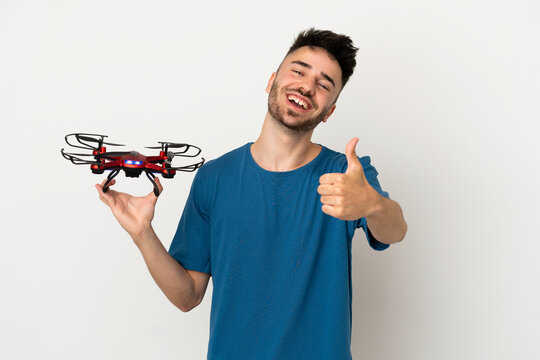 Man holding a drone isolated on white background with thumbs up because something good has happened