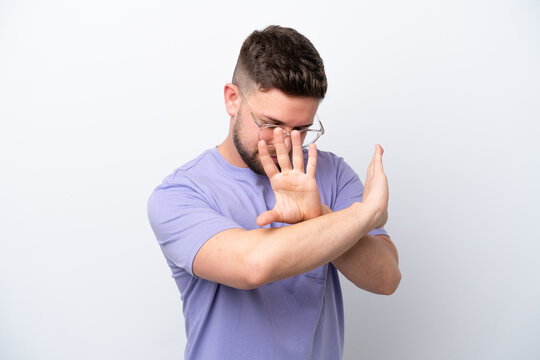 Young caucasian man isolated on white background nervous stretching hands to the front