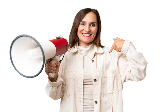 Middle-aged caucasian woman over isolated background holding a megaphone and with surprise facial expression