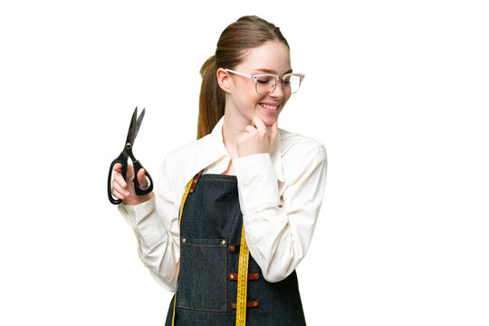 Seamstress woman over isolated chroma key background looking to the side and smiling