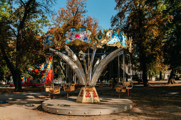 An empty swing carousel stands among autumn trees in Kalemegdan Park in Belgrade. The image fits tourism, recreation, seasonal travel and family leisure concepts. © Ekaterina