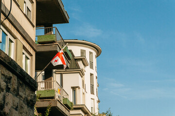 A Georgian national flag hangs from a residential balcony in Belgrade Serbia. The scene suits identity diaspora culture migration politics and international themes. © Ekaterina