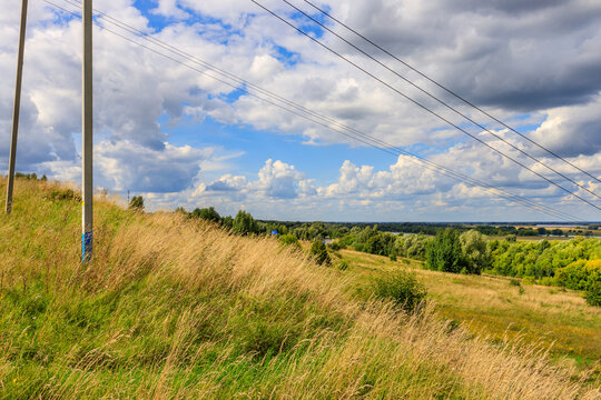 Panoramic view of countryside hills with power cables and cloudy sky