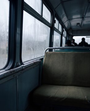 Empty seat beside a fogged window inside a commuter bus in the morning