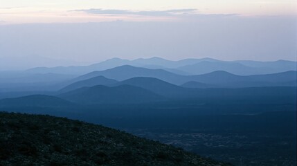 Fototapeta premium The Layered Blue Mountain Range at Dawn Over a Silent Horizon Landscape