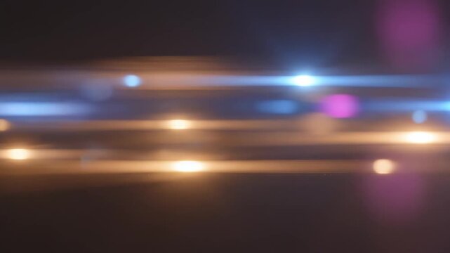 Abstract light streaks moving across a dark background with bokeh highlights during a cinematic motion sequence