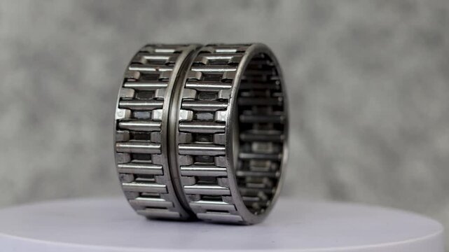 Static shot of Double row needle roller bearing assembly rotating on display stand in workshop.