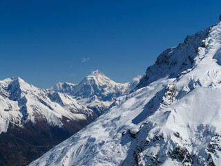 Obraz premium Stunning snow-capped Himalayan mountain peaks under a clear blue sky in the Annapurna region