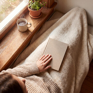 Quiet moment with tea and a book beside a sunny window