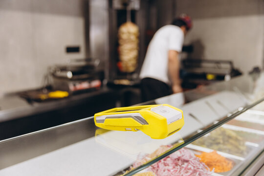 Contactless payment terminal on counter, offering easy transactions in a bustling shawarma restaurant kitchen