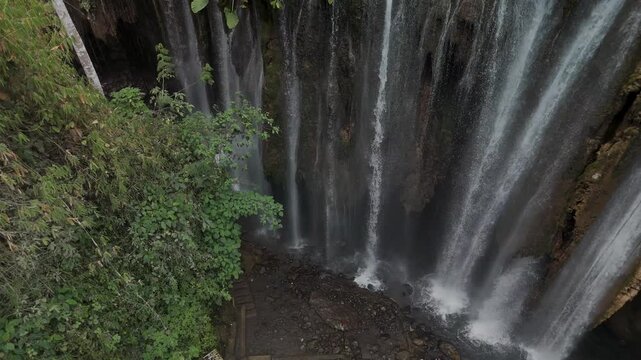 Breathtaking View of a Majestic Waterfall Surrounded by Lush Greenery and Rocks