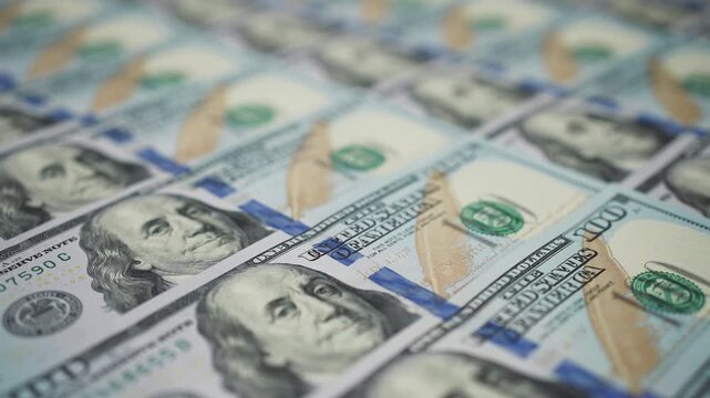 dolly shot of us hundred dollar bills lying neatly in row focus