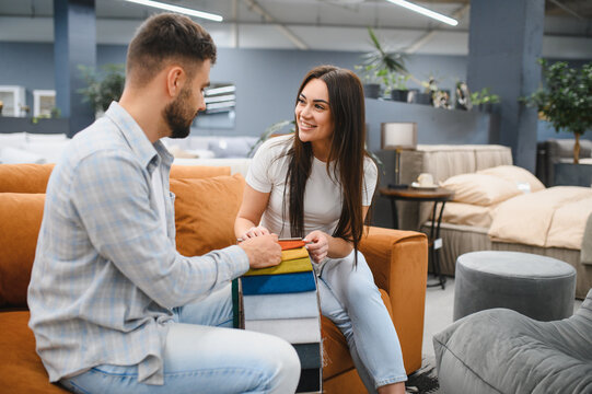 Couple choosing fabric for sofa in furniture store