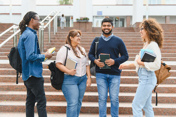 Fototapeta premium Diverse students talking on university campus stairs