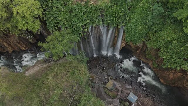 A Stunning Aerial View of Lush Green Waterfall Surrounded by Nature and Serenity