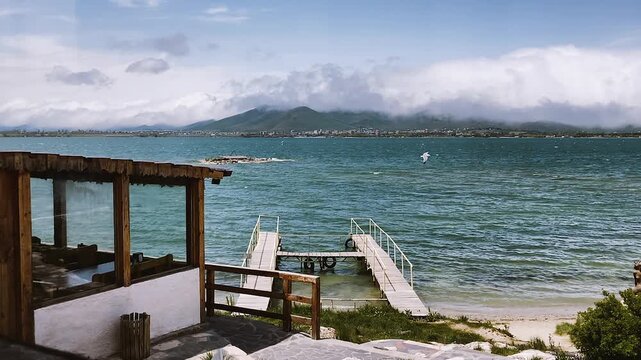 Dramatic view at lake with big clouds, pier leading into water. Sevan, Armenia