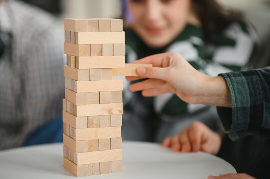 Friends playing stacking tower wood block game