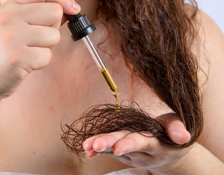 Woman applying hair serum closeup. Cosmetic product. Beauty product applying on hair. Treatment of beauty .