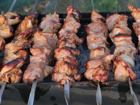 shish kebab on the grill, Juicy pork shish kebab cooking on skewers over hot coals 
