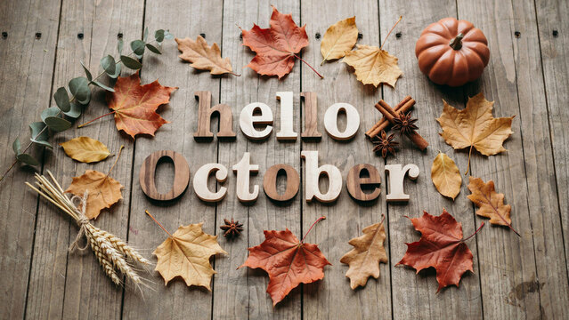 Rustic Hello October wooden text on vintage background, autumn leaves and pumpkin flat lay, seasonal fall greeting card