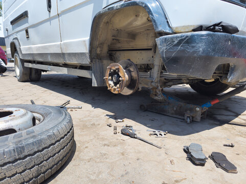 Vehicle maintenance with tire change and brake repair outdoors