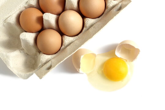 There is a paper container with chicken eggs on a white background.