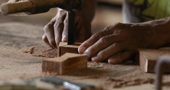 Skilled carpenter working with hand tools to shape and cut wood in a workshop, highlighting traditional craftsmanship, woodworking, furniture making and manual labor.