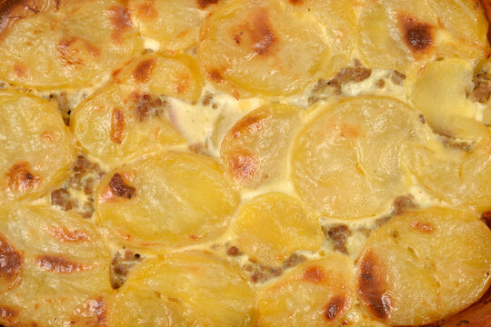 Top view close up of a traditional baked moussaka with layers of sliced golden potatoes and minced meat casserole.