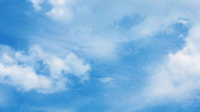 Beautiful time-lapse of soft white cumulus clouds drifting gracefully across a vibrant blue sky on a bright sunny day, perfect background for weather and freedom topics.