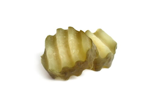  Two slices of pickled cucumber lie on a white background.