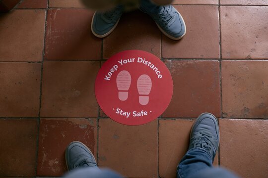 The Red Circle Distance Sign on Floor Promoting Social Distancing