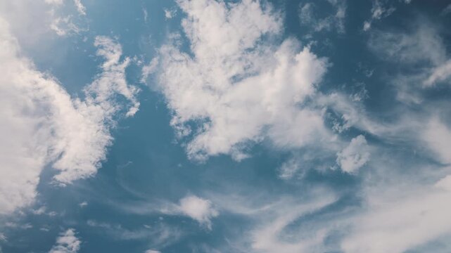Clouds moving across a blue sky in a time-lapse, showing changing weather patterns, atmospheric movement, sunlight and natural sky conditions for weather and environmental content.