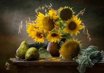 Obraz premium Still life with pears and a bouquet of sunflowers against a dark background