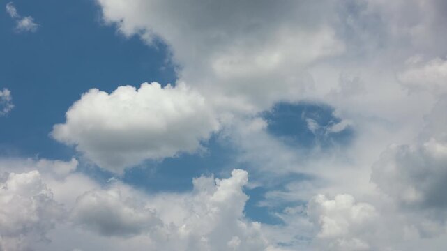 Clouds moving across a blue sky in a time-lapse, showing changing weather patterns, atmospheric movement, sunlight and natural sky conditions for weather and environmental content.