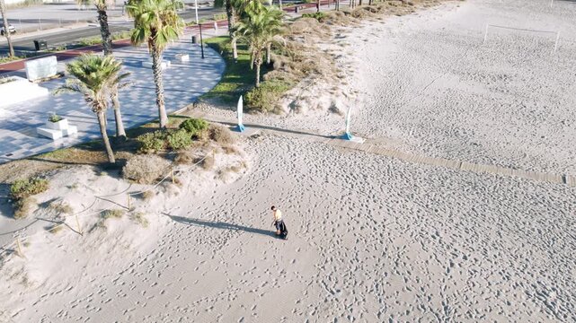 Aerial View of Person Cleaning Up Trash on Sandy Beach