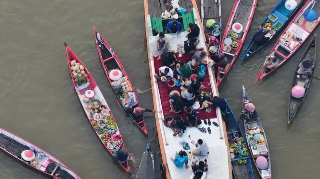 Traditional wooden boats trade fresh produce and goods at Lok Baintan Floating Market in Borneo
