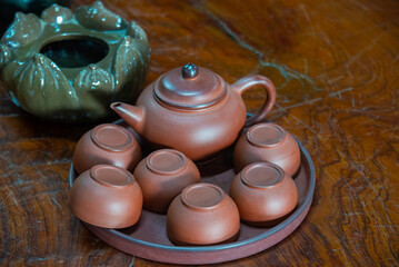 Traditional brown ceramic tea set arranged on a wooden table in Bac Ninh, Vietnam, featuring a...
