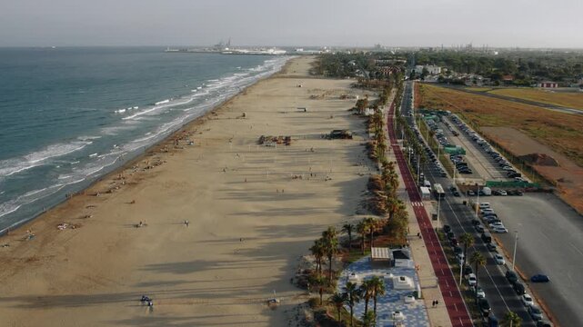 Aerial view of sandy beach and coastal road at sunset