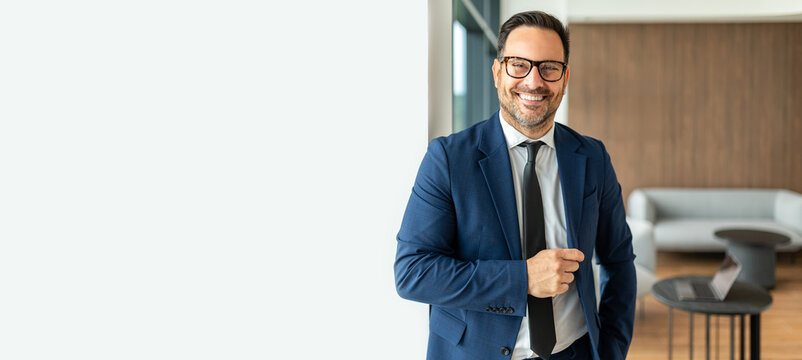 Professional male executive smiling confidently in a modern office environment, representing leadership, success, business expertise, and corporate responsibility